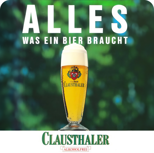 A glass of beer is displayed against a blurred green background, emphasizing its frothy top.
