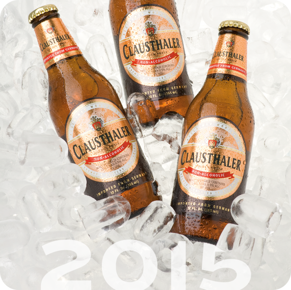 Three bottles of non-alcoholic beverage are chilled in a bed of ice cubes.