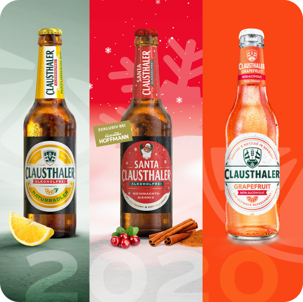 Three bottles of non-alcoholic Clausthaler drinks are displayed, each with distinct flavors indicated by accompanying fruits and spices.