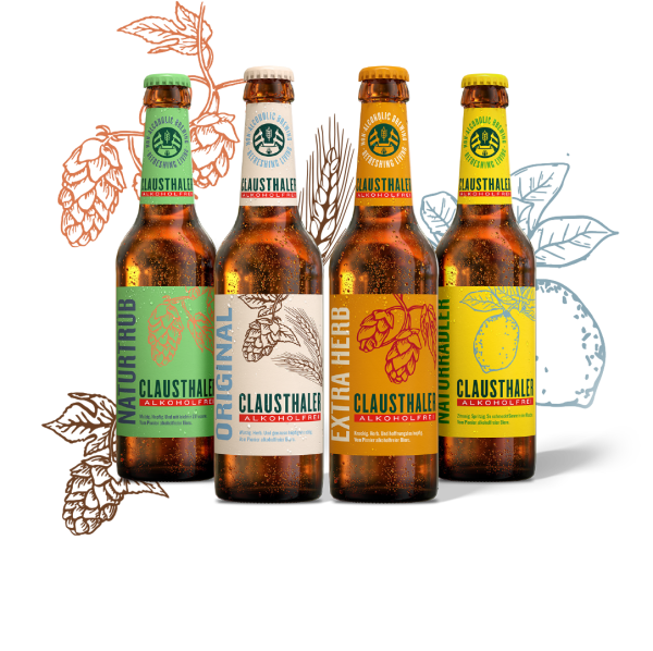 Vier Flaschen alkoholfreies Bier mit bunten Etiketten und Hopfendesigns vor stilisierten Blättern.