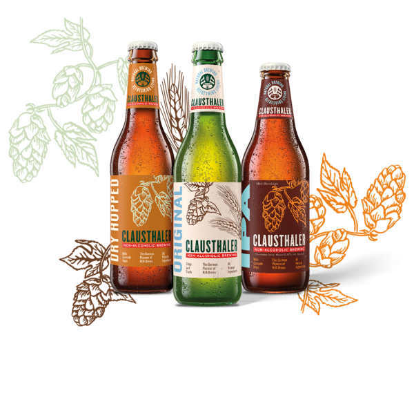 Tre bottiglie di birra analcolica con etichette colorate e motivi di luppolo davanti a foglie stilizzate.